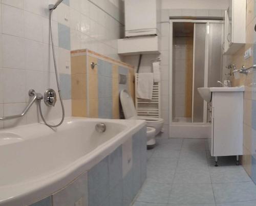 a white bathroom with a tub and a toilet at Penzión Zlatý Dukát in Zvolenská Slatina