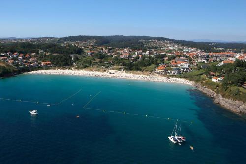 an aerial view of a beach with boats in the water at Apartamentos Limar Portonovo - Sanxenxo in Portonovo