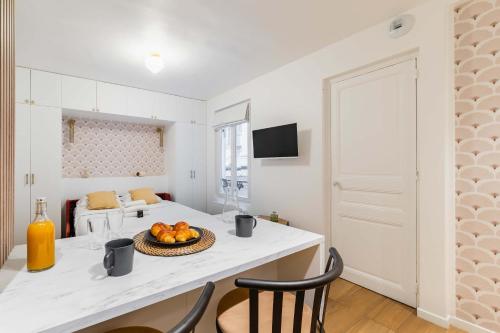 une cuisine avec une table avec un bol de fruits dessus dans l'établissement Studio parisien coeur montmartre - Paris 18 - 2p, à Paris