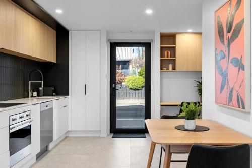 a kitchen with a table and a dining room at Stylish Stay Heart of the CBD in Christchurch