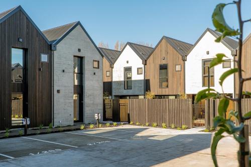 a row of houses with a fence and a parking lot at Stylish Stay Heart of the CBD in Christchurch