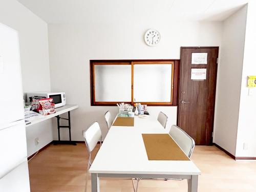 a white dining room with a white table and chairs at D Hotel - Vacation STAY 89642v in Tokyo