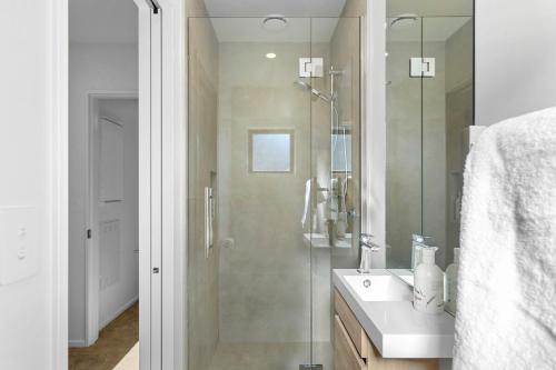 a bathroom with a shower and a sink and a mirror at Stylish Stay Heart of the CBD in Christchurch