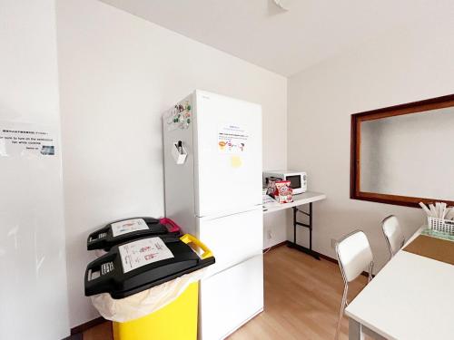 a kitchen with a refrigerator and a table and a whiteboard at D Hotel - Vacation STAY 89642v in Tokyo