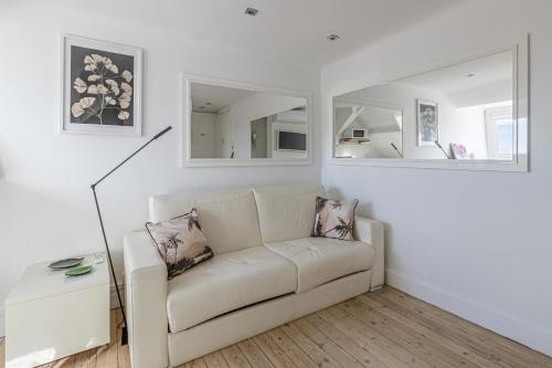 - un salon blanc avec un canapé et des miroirs dans l'établissement LE VANILLE studio cosy au cœur de la Banane, à Cannes