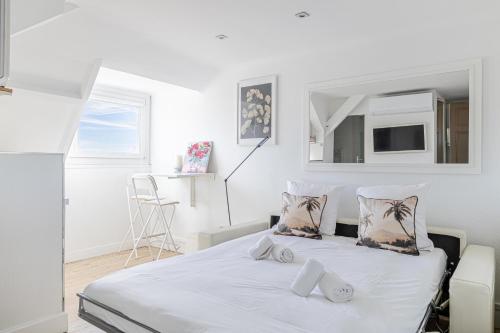 une chambre blanche avec un lit et une chaise dans l'établissement LE VANILLE studio cosy au cœur de la Banane, à Cannes