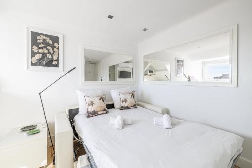 une chambre blanche avec un lit et un miroir dans l'établissement LE VANILLE studio cosy au cœur de la Banane, à Cannes