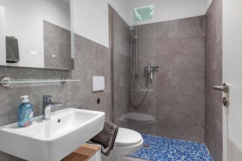 a bathroom with a sink and a toilet and a shower at Ferienwohnung Möckmühl in Möckmühl