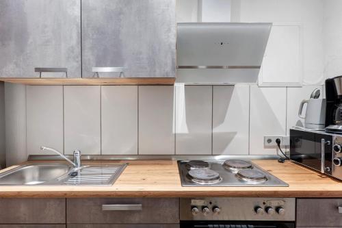 a kitchen with a sink and a stove top oven at Ferienwohnung Möckmühl in Möckmühl