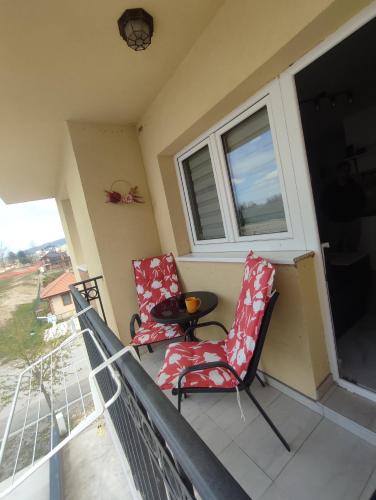 a balcony with two chairs and a table and a window at Apartman Nina in Ostrovo