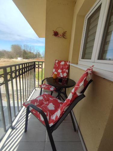 a balcony with a table and a chair on a porch at Apartman Nina in Ostrovo