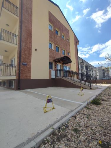 a building with two yellow barricades in front of it at Apartman Nina in Ostrovo