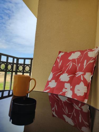 an orange mug sitting on a balcony with a pillow at Apartman Nina in Ostrovo