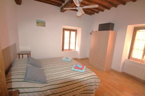 a bedroom with a bed and a ceiling fan at Lo Scricciolo in Montecastelli Pisano