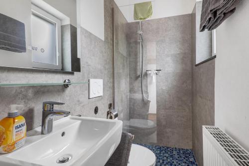 a bathroom with a sink and a toilet and a shower at Ferienwohnung Möckmühl in Möckmühl