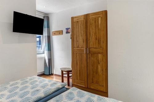 a bedroom with a wooden cabinet and a bed at Ferienwohnung Möckmühl in Möckmühl