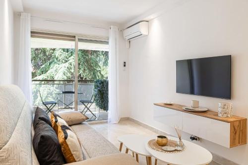 un salon avec un canapé et une télévision dans l'établissement LE CENTER avec joli balcon et parking pour un plaisant séjour, à Cannes