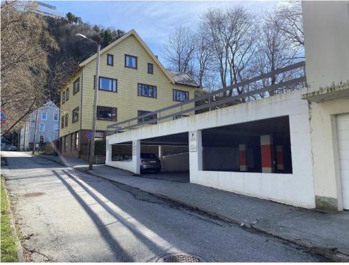 a building with a garage with a car under it at Downtown free parking cozy apartment in Ålesund