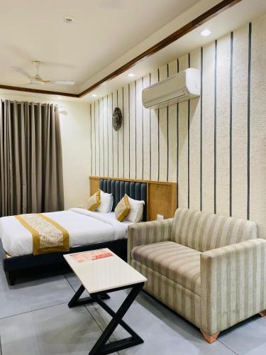 a hotel room with a bed and a couch at Rosewood Grand in Faridabad