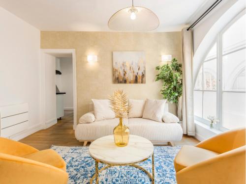 un salon avec un canapé et une table dans l'établissement Merveil - Family Suite - Louvre - Dalayrac, à Paris