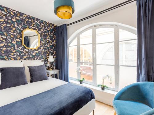 une chambre avec un lit, une fenêtre et une chaise dans l'établissement Merveil - Family Suite - Louvre - Dalayrac, à Paris