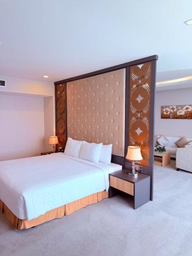 a large bedroom with a large bed and a couch at Muong Thanh Luxury Nha Trang Hotel in Nha Trang