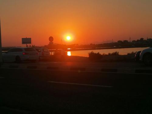 a sunset in a parking lot with the sun setting at Il mare b&b in Quartu SantʼElena