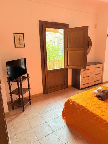 a bedroom with a bed and a television and a window at Casa di Marco in Galatina