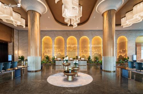 a lobby with tables and chairs and a fountain at Radisson Blu Ha Long Bay in Ha Long
