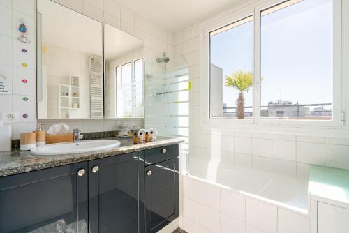 une salle de bain avec une baignoire, un lavabo et un miroir dans l'établissement Veeve - Romantic Terrace, à Paris