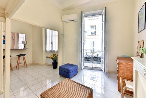 - un salon avec un pouf bleu et une fenêtre dans l'établissement LE RÉTRO studio avec mezzanine en plein centre, à Cannes