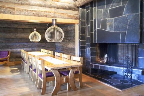 a dining room with a table and a fireplace at Saariselkä Kelo Lodge in Saariselka