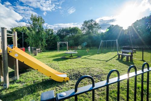 a playground with a yellow slide in a park at Argus 4-Bed Haven, Contractor, Families, Industrial Area in Hemel Hempstead