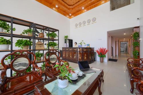 a dining room with a table with a laptop on it at Soul History Hotel Phu Quoc in Phu Quoc