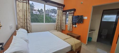 a small bedroom with a bed and a window at BH Sunrise Villa Yercaud in Yercaud