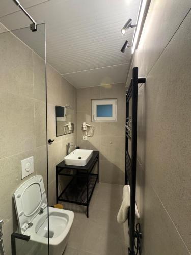 a small bathroom with a sink and a toilet at Rooms at Mimosa Street in Tirana