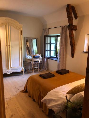 Cette chambre comprend 2 lits dans une chambre avec 2 fenêtres et une table. dans l'établissement Watermill Barn Dordogne, à Gintrac
