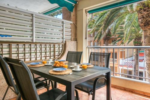 ein Tisch mit Essen auf einem Balkon mit Blick auf eine Palme in der Unterkunft La Terraza De Palmeres in Mareny Barraquetas