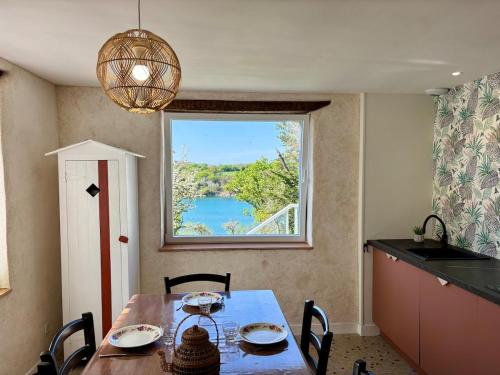 une salle à manger avec une table et une grande fenêtre dans l'établissement Ty Bugale - Sea view house - Nature - 6 people, à Moëlan-sur-Mer