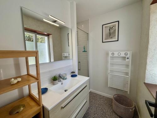 une salle de bain avec un lavabo et un miroir dans l'établissement Ty Bugale - Sea view house - Nature - 6 people, à Moëlan-sur-Mer
