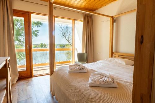 a bedroom with a bed with two towels on it at LivingIn Delta - Casa de Vacanta in Crisan
