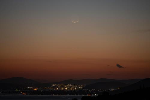a view of the sun setting over a city at Karavia Lux Inn in Afissos