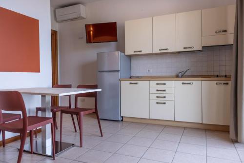 a kitchen with a refrigerator and a table and chairs at Residence Solei Classic & Plus in Brenzone sul Garda