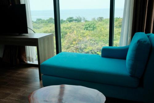a blue couch sitting in front of a large window at KEP BAY HOTEL & RESORT in Kep