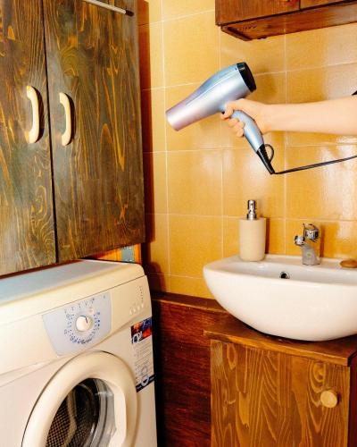 a person holding a blow dryer above a sink at Comfy and central with bikes in Bohinj