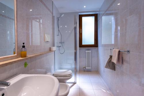 a bathroom with a tub and a toilet and a sink at Residence Solei Classic & Plus in Brenzone sul Garda