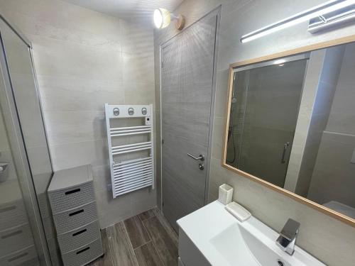 une salle de bain avec un lavabo et un miroir dans l'établissement L'écrin des Pins, à Sausset-les-Pins