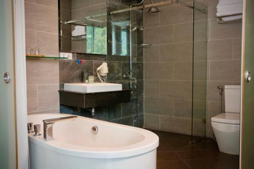 a bathroom with a tub and a sink and a toilet at KEP BAY HOTEL & RESORT in Kep