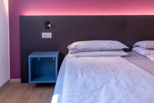 a bedroom with a large bed and a blue table at Residence Solei Classic & Plus in Brenzone sul Garda