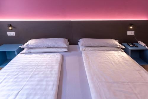 a room with two beds and a desk at Residence Solei Classic & Plus in Brenzone sul Garda